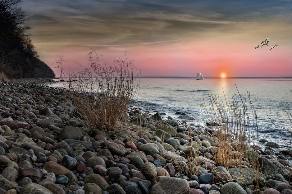 日落时海岸上褐色和灰色的石块