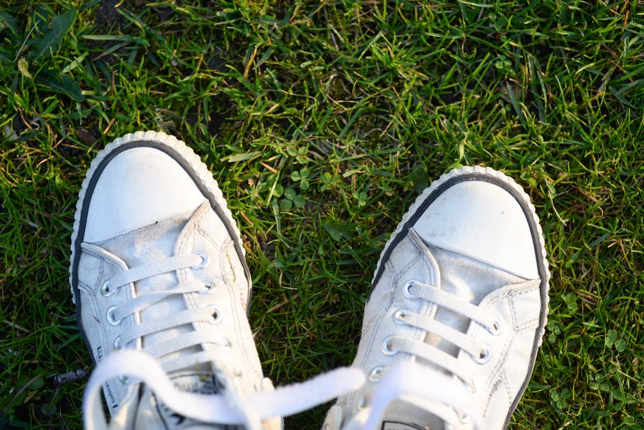 Green Grass上的一双白色蕾丝运动鞋