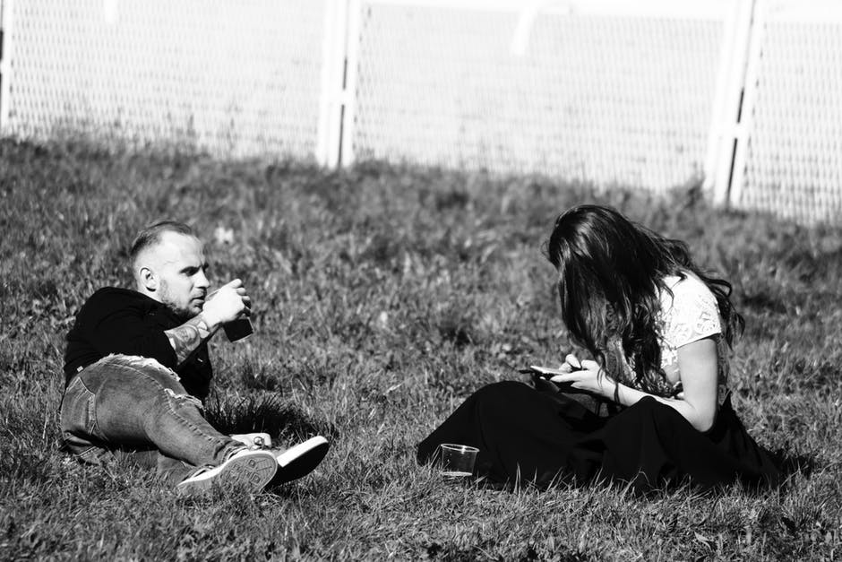 草地上的男人和女人的灰度摄影