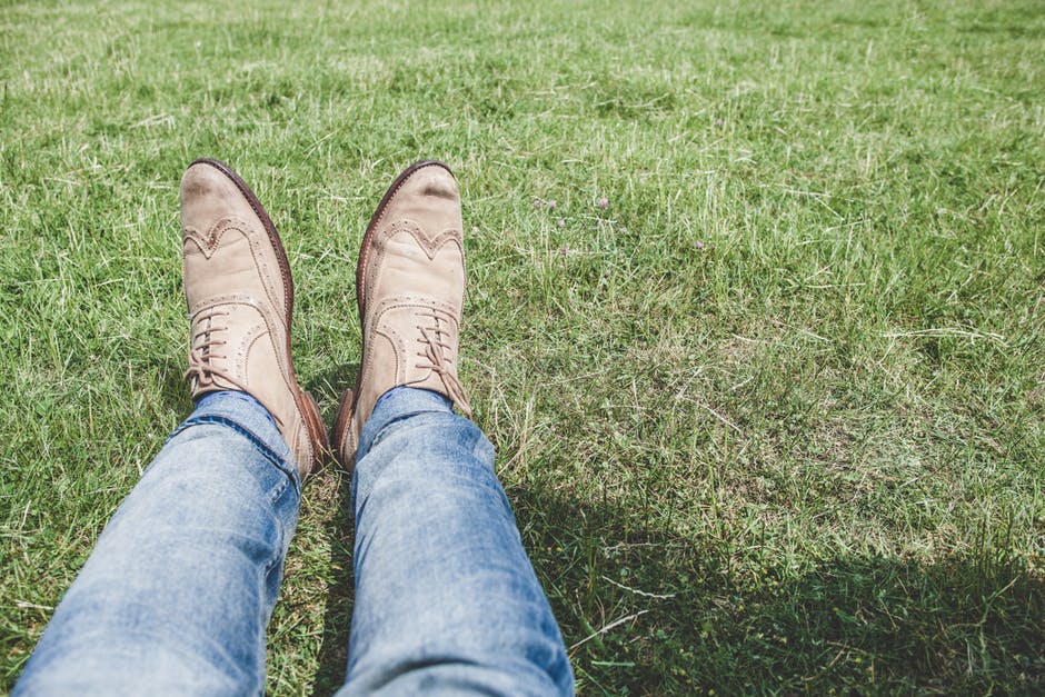 穿着蓝色牛仔裤的人坐在草地上