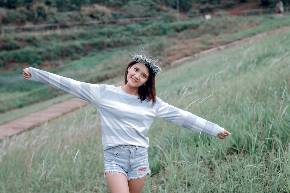Woman Wearing Gray和白色条纹毛衫在绿色草地上的选择性聚焦照片