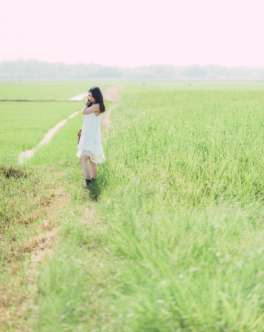 穿着白色衣服的女人站在绿色的草地上
