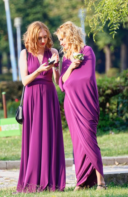 草地上穿紫色衣服的两个女人