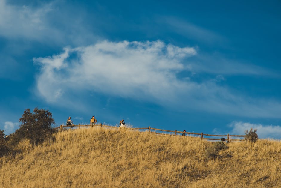 四个人站在山顶上用篱笆