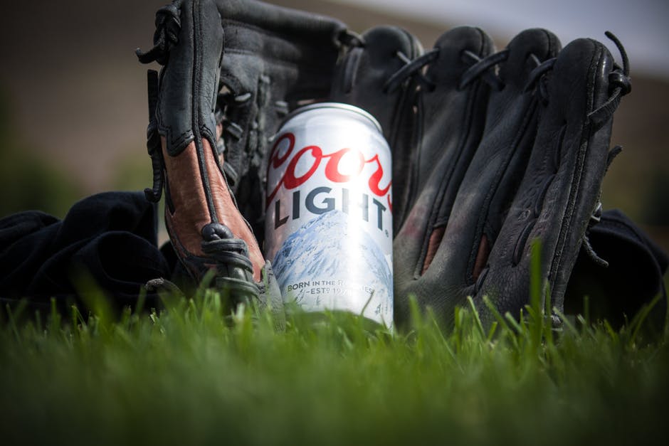 黑色棒球手套附近科尔斯淡啤酒的近景摄影