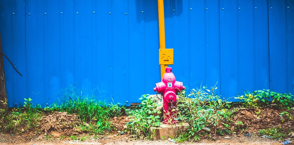 蓝篱笆后的粉色钢水泵