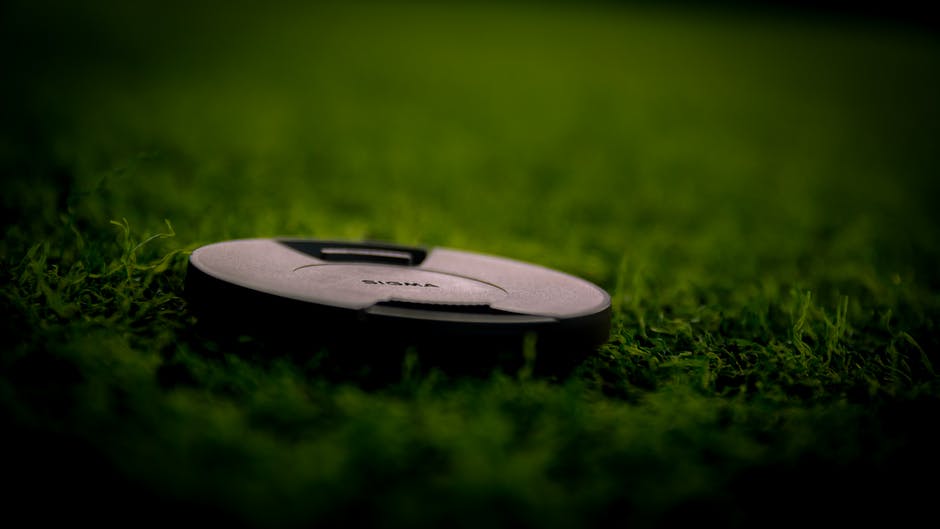 绿色草地上的黑色相机镜头盖