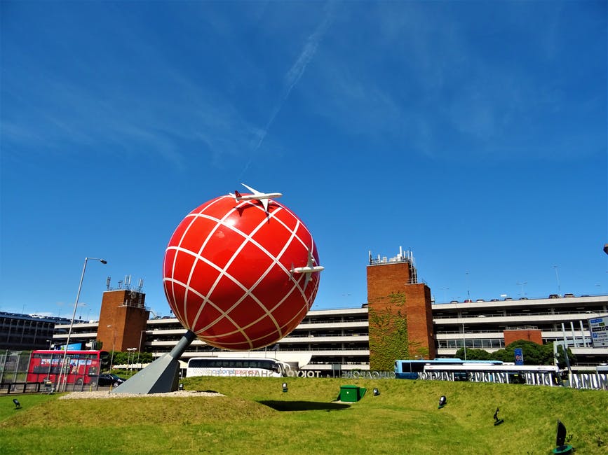黑白混凝土建筑附近的红色和白色地球雕像
