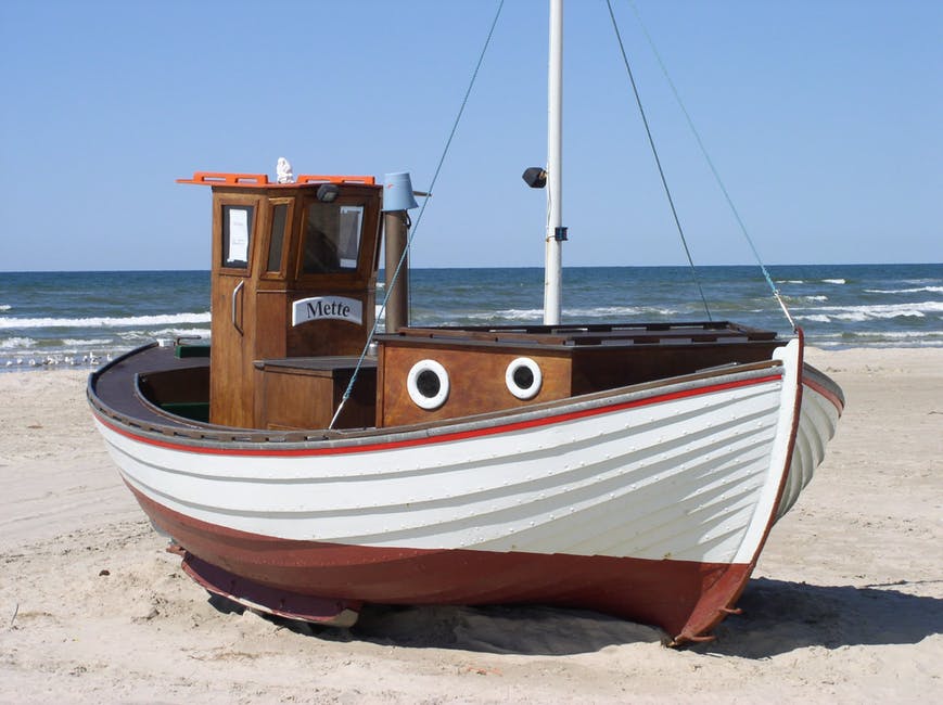 白昼白色沙滩上的Brown Speedboat与白雪公主