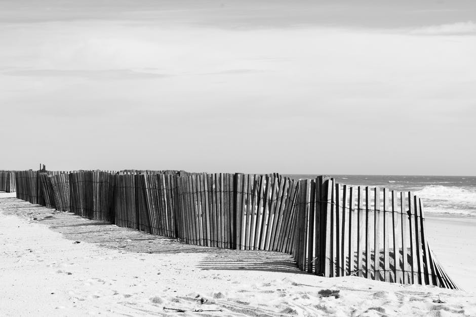 海滩附近栅栏的灰阶照片