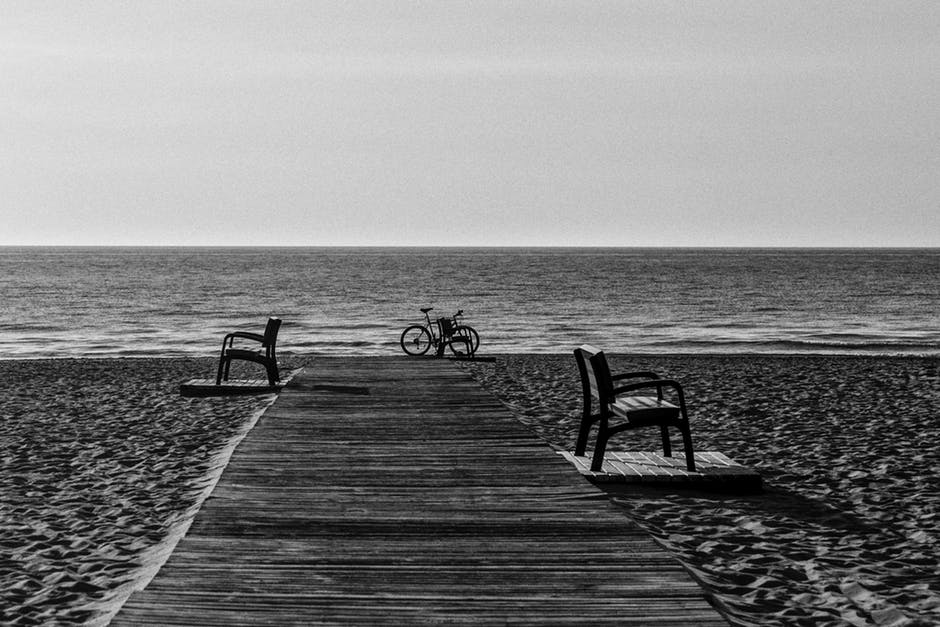 海边沙滩自行车的灰阶照片