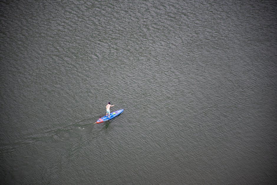 在水上骑蓝色和红色桨板的人