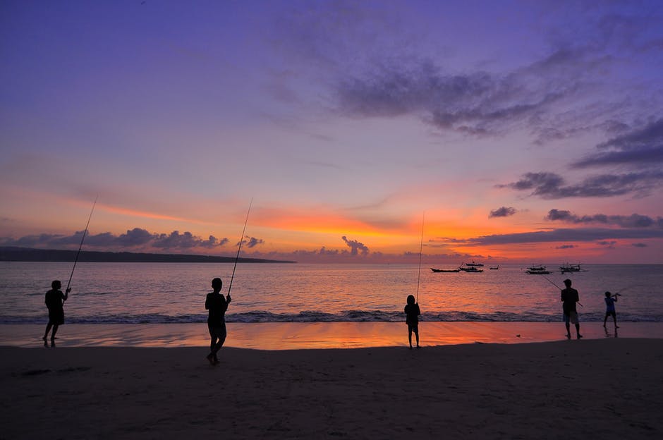 日落时五人站在海边的剪影