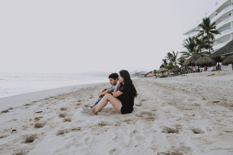 坐在沙滩上的男人和女人
