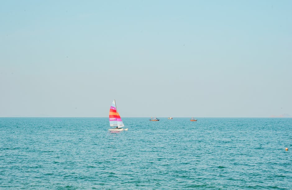 蓝色海洋上的白色和粉色帆船