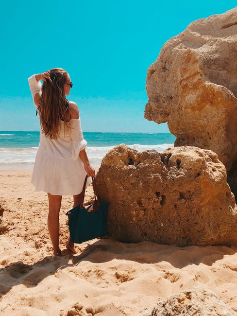 站在海滩边岩石旁的女人
