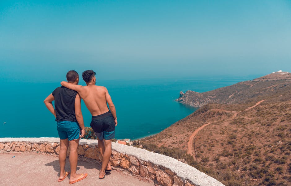 两个人站在海景上的山崖上