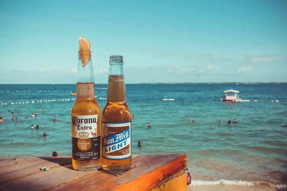 海滩附近褐木板顶部的两种电晕和三米格轻质啤酒