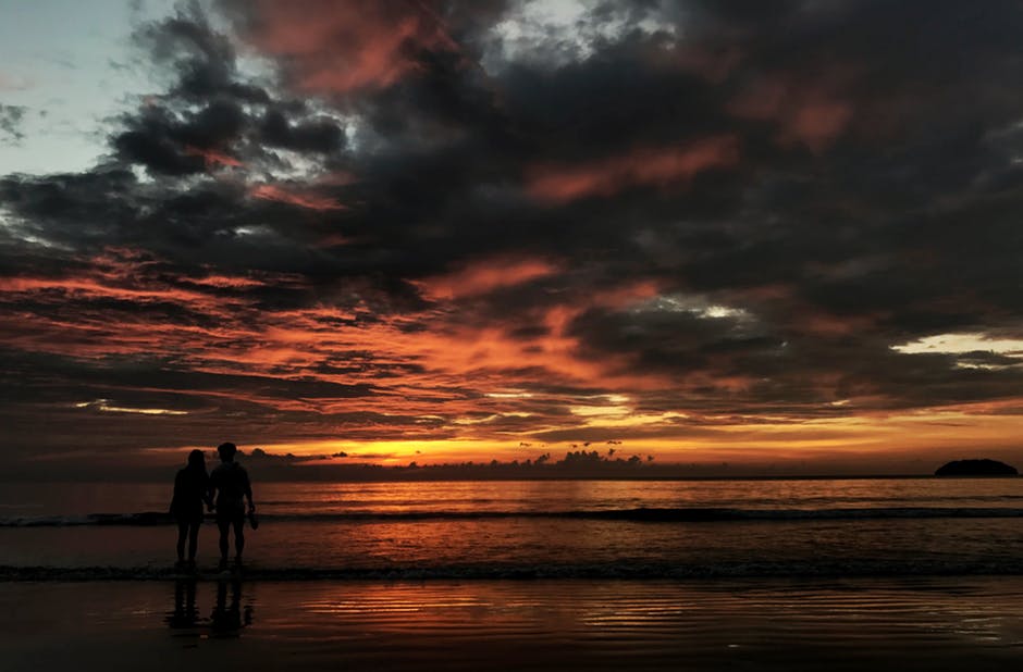 两个人站在海滩剪影照片
