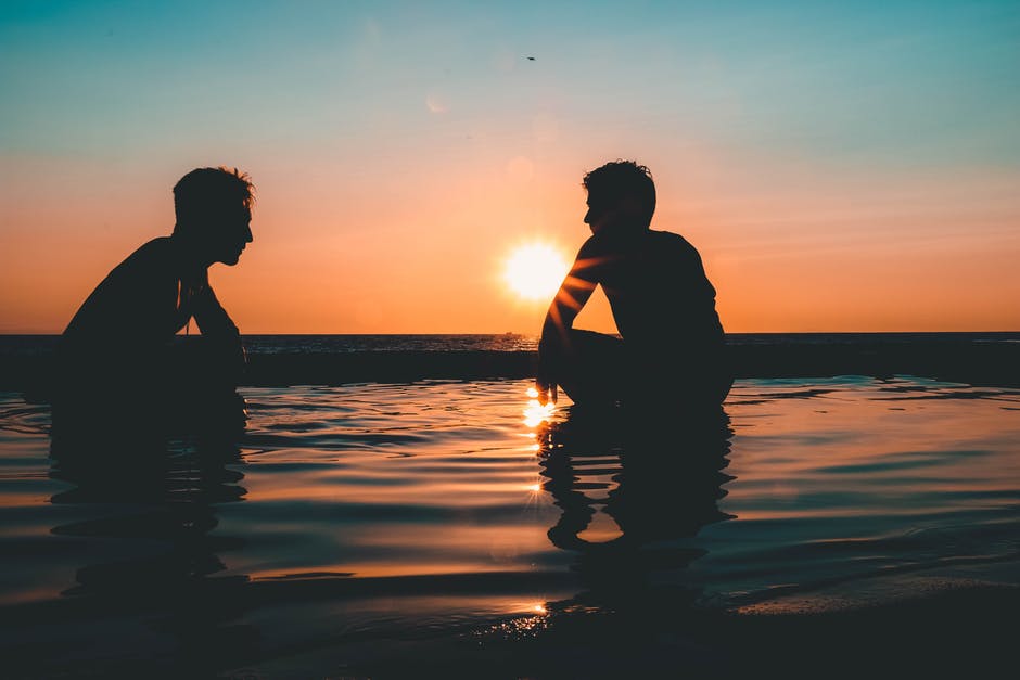 夕阳西下两个人在海边的照片
