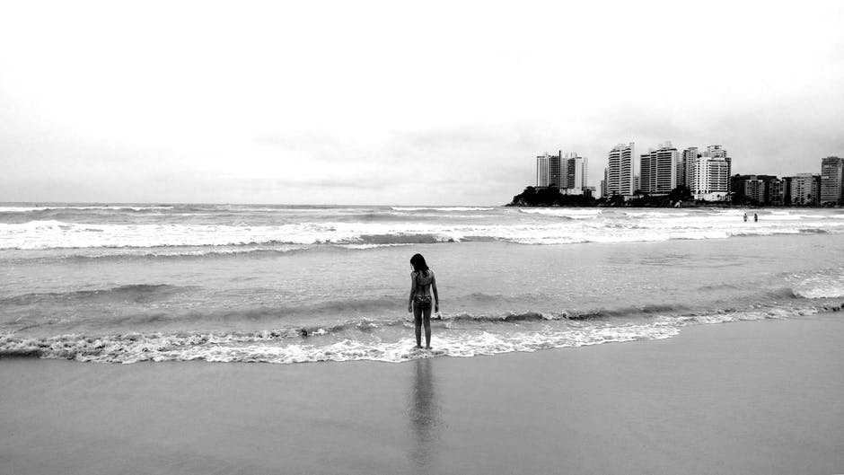 女性站立海岸灰阶照片