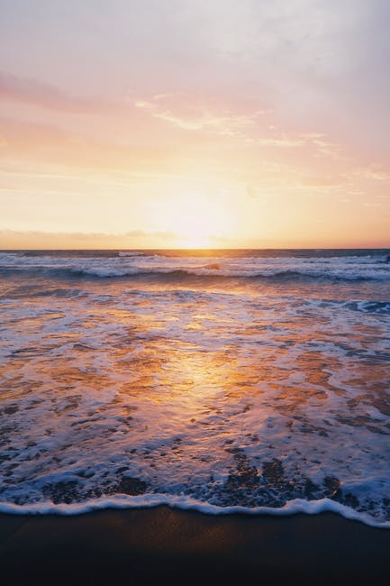 日落期间海岸附近海浪的照片