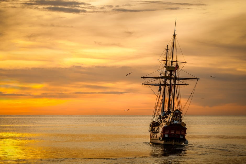 日落时海上的棕色帆船