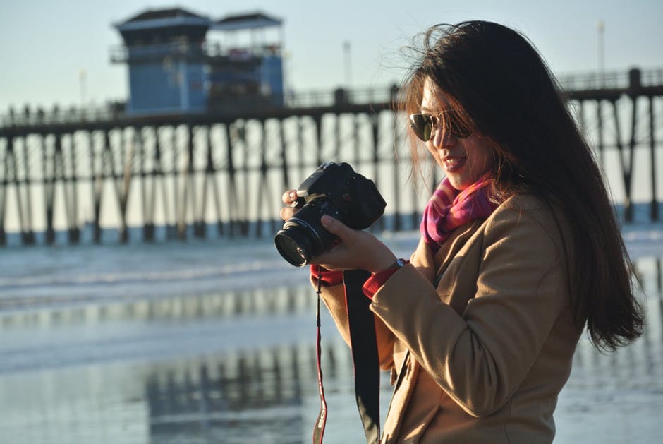 海岸附近妇女握持相机的选择性聚焦摄影